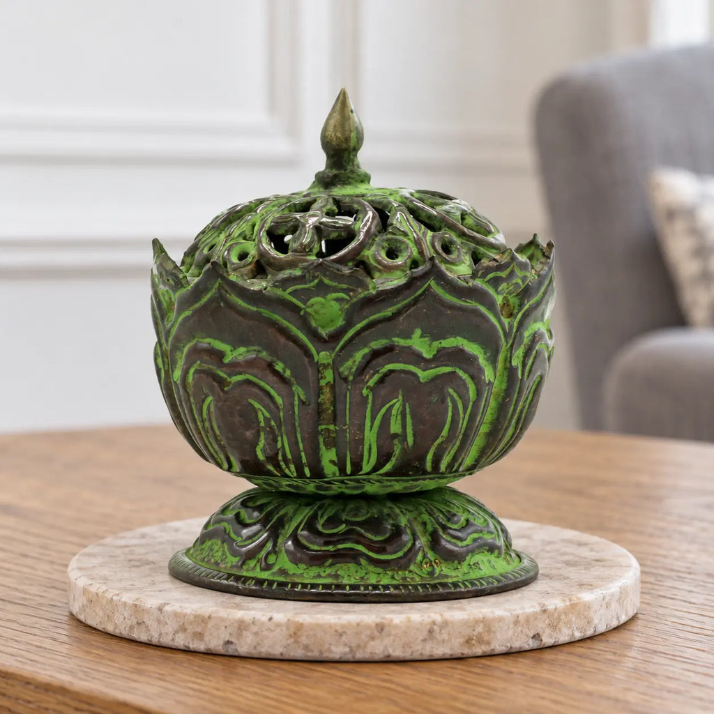 Small brass verdigris Tibetan lotus incense burner with its pierced lid, on an oak console in a British sitting room.