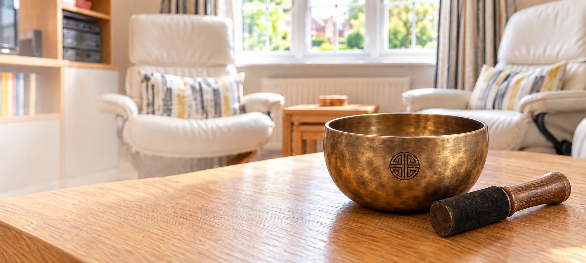 Tibetan singing bowl and striker on a wooden table in a British living room